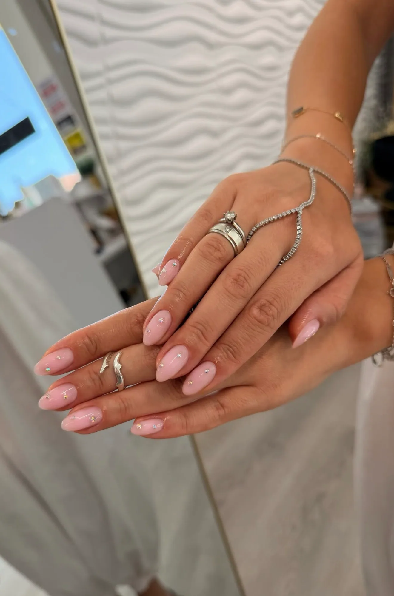 Soft pink almond manicure with delicate rhinestone accents